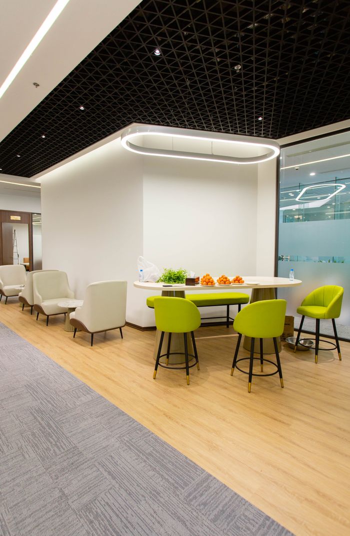 Home A stylish office interior featuring a contemporary seating area with green and white chairs.